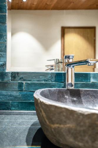 a bathroom with a stone sink and a mirror at das MOOSWALD in Obsteig