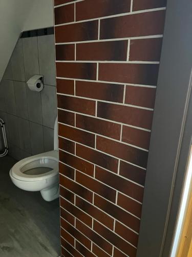 a bathroom with a brick wall and a toilet at Apalucha119 in Ludvíkov