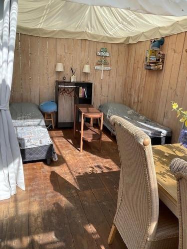 a room with a tent and a table and chairs at Vrijstaande accommodatie Glamping de Kas InN in Hank