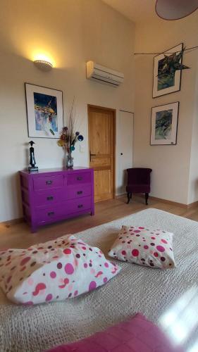 - une chambre avec une commode violette et 2 oreillers sur un lit dans l'établissement appartement dans villa aquarelle, à Biguglia