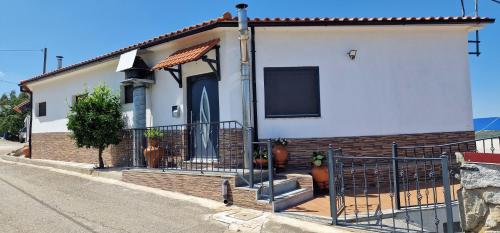 a small white house with a black gate at Estalagem Soeiro Meireles, Unipessoal, LDA in Lagoaça