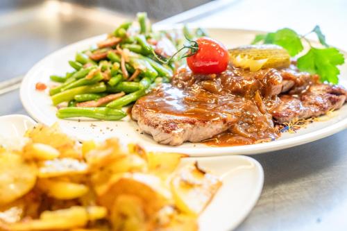 two plates of food with meat and vegetables on a table at das MOOSWALD in Obsteig