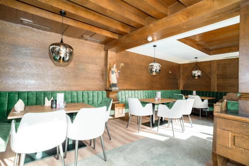a restaurant with wooden walls and white chairs and tables at das MOOSWALD in Obsteig