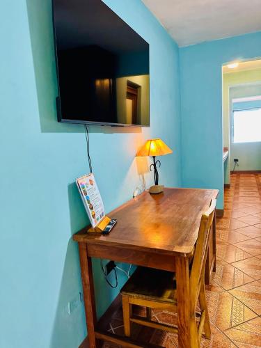a wooden table with a lamp on a blue wall at Lake Arenal Hotel & Brewery in Tilarán