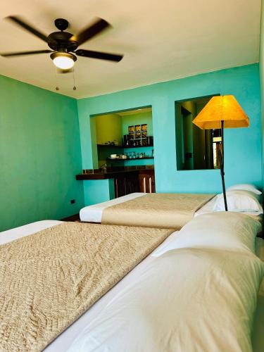 a bedroom with two beds and a ceiling fan at Lake Arenal Hotel & Brewery in Tilarán