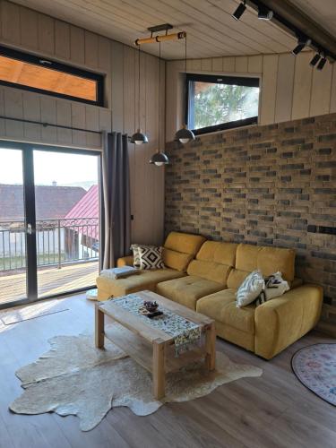 a living room with a couch and a brick wall at Luxusný apartmán Karolína in Telgárt