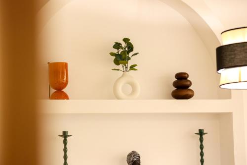 a shelf with a plant and vases on it at SanPietro Vacation Apartments in Durrës