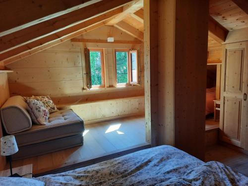 a room with a couch and windows in a cabin at Tabià Su'n Coi in Alleghe