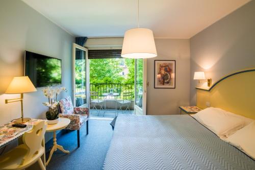a hotel room with a bed and a table and chairs at Albergo Milano Snc in Lanzo dʼIntelvi