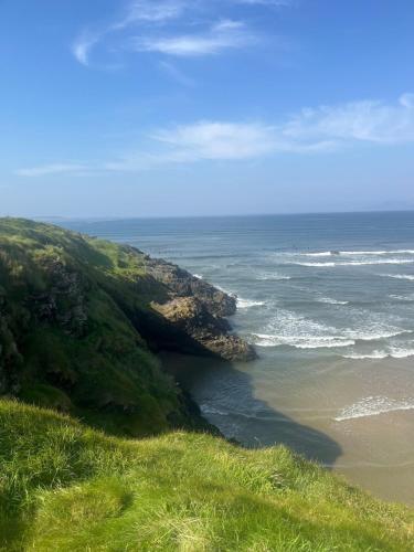 a view of a beach and the ocean from a hill at Beach Apartment Bundoran in Bundoran