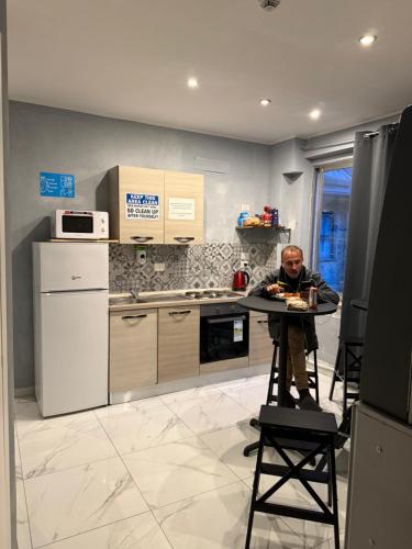 a man sitting at a table in a kitchen at Lion University & Youth Hostel Milano in Milan