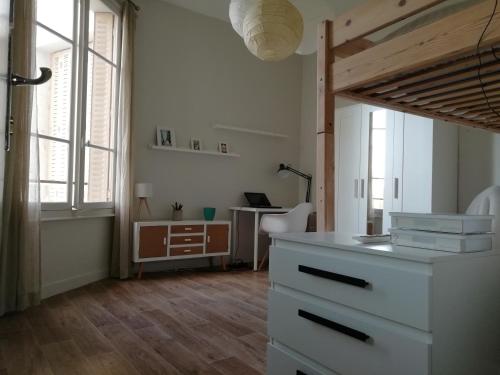 une pièce avec un bureau et une table avec une lampe dans l'établissement Grand studio centre historique, à Vichy