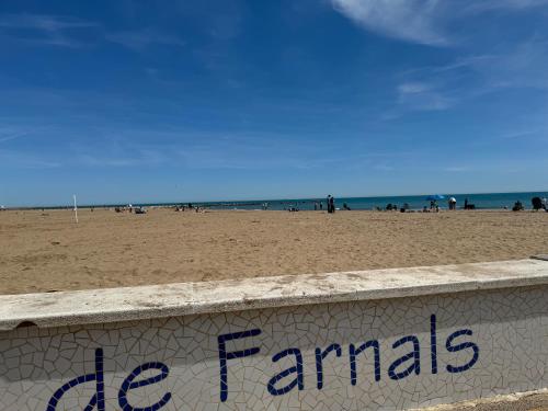 a wall on a beach with people on the beach at Puebla de Farnals playa- Oasis Apartments - Costa de Valencia Beachside Stay in Puebla de Farnals