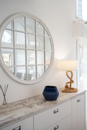 - un miroir rond sur un mur blanc dans le salon dans l'établissement Villa Ocean, à Biscarrosse