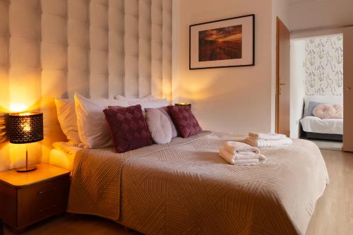 a bedroom with a large bed with a large headboard at APARTAMENTY VILLA PIGMALION - sauna, jacuzzi, parking, ogród in Kudowa-Zdrój