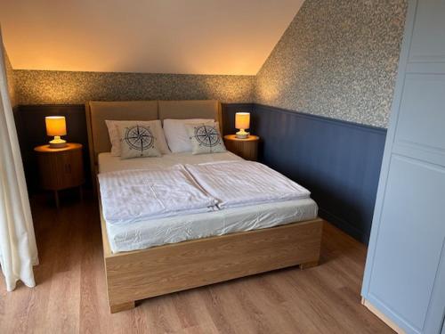 a bedroom with a bed with two lamps on two tables at Apartamenty Dolina Wisełka in Wisełka