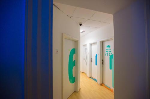 a hallway of an office with doors with green at Hostel Kosy in Rijeka