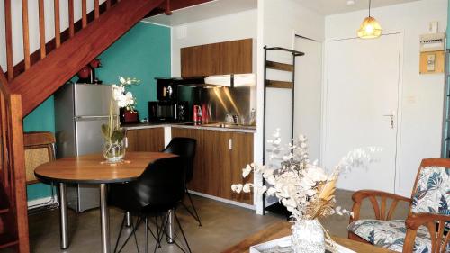 a kitchen with a table and a kitchen with a staircase at FLOREVA 22 entre Plage et Thalasso - Internet fibre in Concarneau