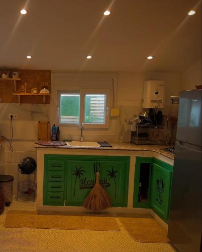 a kitchen with a green island with a sink at Bitty house in Boumerdes