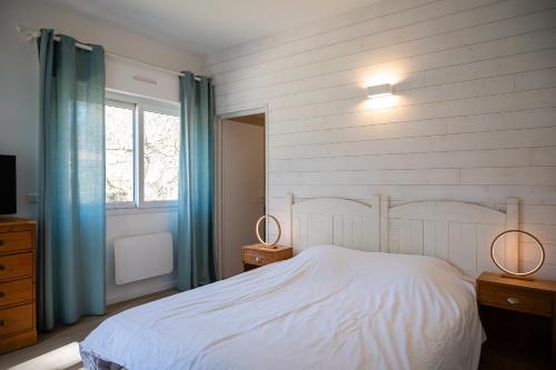 une chambre avec un lit blanc et une fenêtre dans l'établissement Villa Ocean, à Biscarrosse
