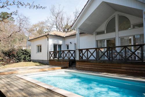 une maison avec une piscine devant une maison dans l'établissement Villa Ocean, à Biscarrosse