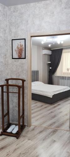 a bedroom with a large bed and a wooden floor at 1 ком ТРЦ Костанай плаза in Kostanay