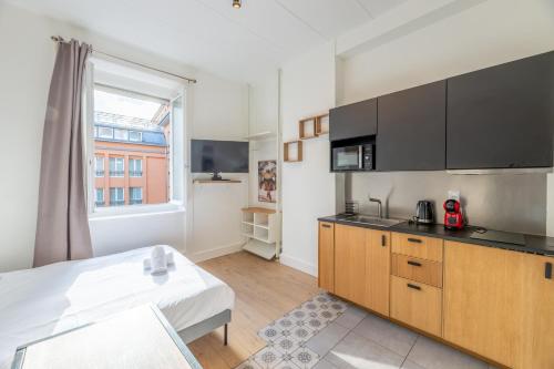 Cette chambre dispose d'une cuisine avec un lit et un four micro-ondes. dans l'établissement Escapade de Lyon, Relax & Balnéo Métro Charpennes, à Villeurbanne