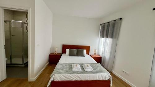 a bedroom with a bed with two towels on it at Amazing Blue House in Ribeira Grande