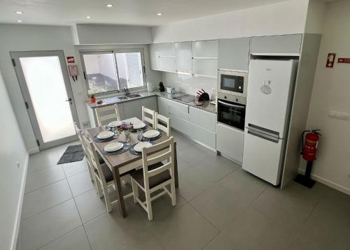 a kitchen with a table and chairs and a refrigerator at Amazing Blue House in Ribeira Grande