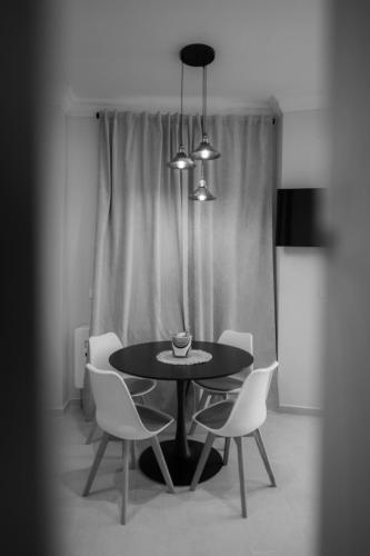 a black table with white chairs in a room at Apartamento Don Marcos A in Badajoz