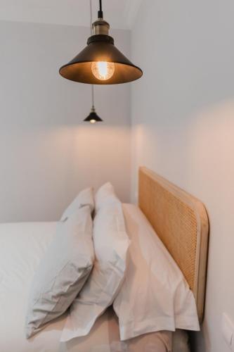 a bedroom with a bed with two pillows and a lamp at Apartamento Don Marcos A in Badajoz