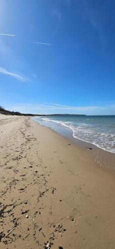 a beach with footprints in the sand and the ocean at Maison au calme avec jardin près du Château, forêt et plage in Condette