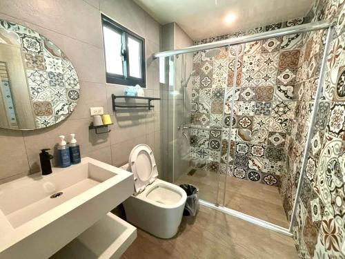 a bathroom with a shower and a toilet and a sink at oceya in Magong