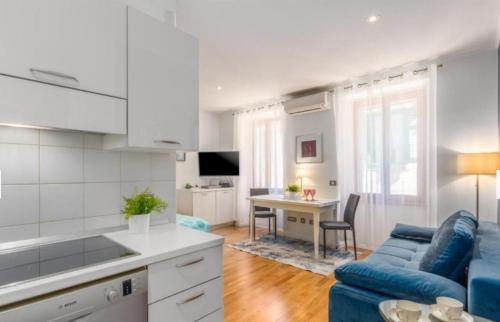 una cucina e un soggiorno con divano blu di Augustina Apartment a Rovigno (Rovinj)