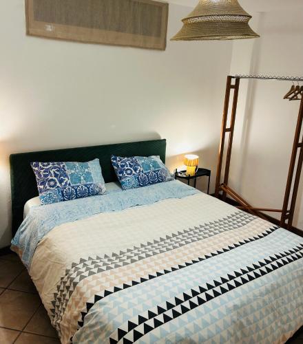 a bed with blue and white blankets and pillows at Civico 7 in Clusane sul Lago