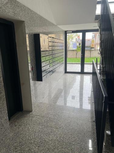 an empty hallway of a building with a glass door at Liam Apartament in Prizren