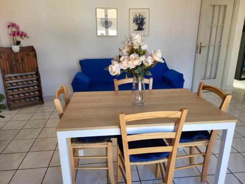 a dining room table with a vase of flowers on it at A due passi dal mare Lovely Apartment Viareggio in Viareggio