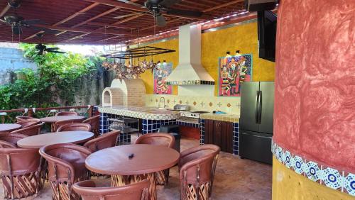 a restaurant with tables and chairs and a refrigerator at Casa Colonial Estate, Cozumel in Cozumel