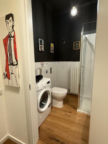 Un baño con lavadora y un inodoro. en Al Centro Città, en Bérgamo