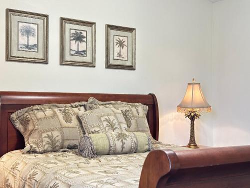 a bedroom with a bed with a lamp and pictures on the wall at Emerald Coast Vacation Destination in Pensacola