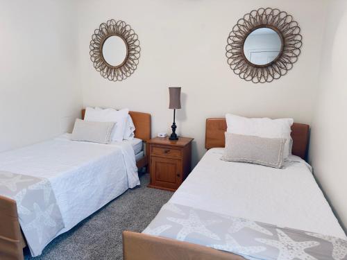 two beds in a room with two mirrors on the wall at Emerald Coast Vacation Destination in Pensacola