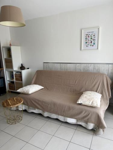 Cette chambre comprend un lit avec deux oreillers et une table. dans l'établissement Appartement 1 chambre avec piscine, à Gréoux-les-Bains