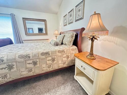 a bedroom with a bed and a table with a lamp at Emerald Coast Vacation Destination in Pensacola