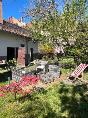 - une terrasse avec des chaises et des fleurs dans la cour dans l'établissement Petit Manoir en Ville - Parking privé - 15 min Hyper-centre, à Strasbourg