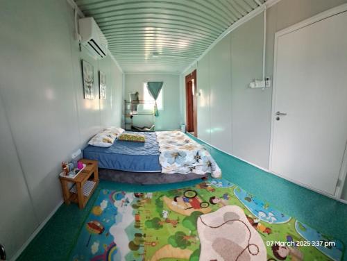 1 dormitorio con 1 cama y suelo con alfombra de tren en Laman Abah Staycation, en Jenjarum