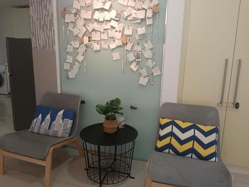 two chairs and a table and a wall with papers at Encorp Strand Suite by Luvit Stay in Petaling Jaya