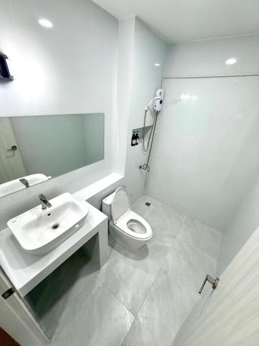 a white bathroom with a sink and a toilet at Sman Resort in Lamai