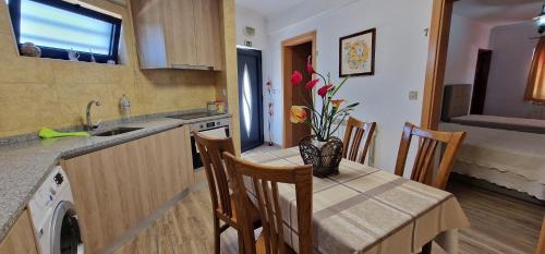 a kitchen with a table with a vase of flowers on it at Estalagem Soeiro Meireles, Unipessoal, LDA in Lagoaça