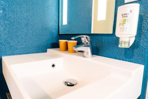 a white sink in a bathroom with a mirror at ibis budget Aix en Provence in Aix-en-Provence