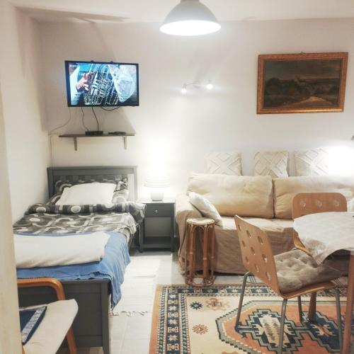 a living room with a couch and a tv on the wall at B&B Family Basement Apartment, Breakfast, Free Parking, 5km from Tulln in Chorherrn
